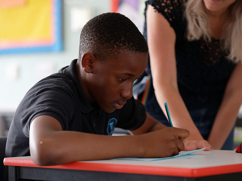 Teacher and child working at desk